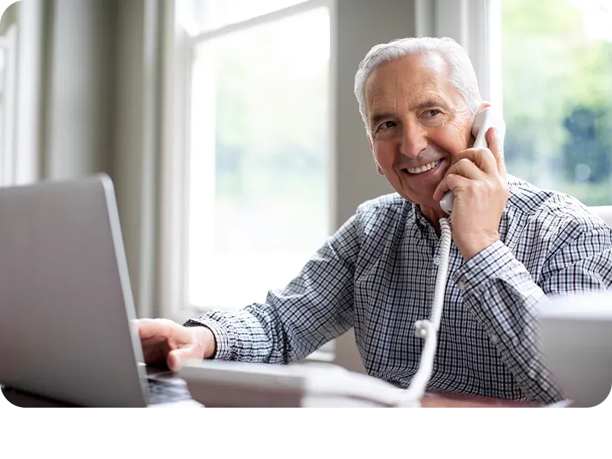 mature man using home phone and laptop