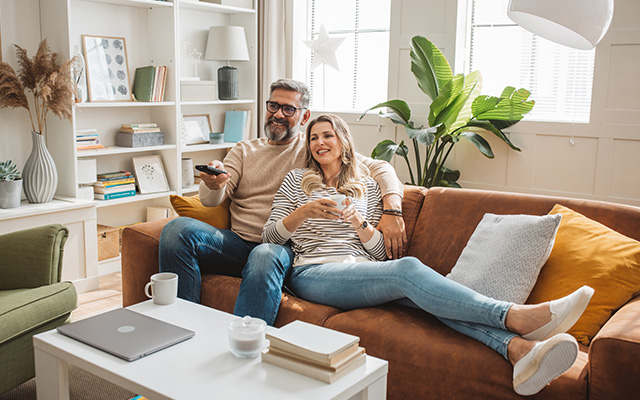 mature couple watching a movie on a couch