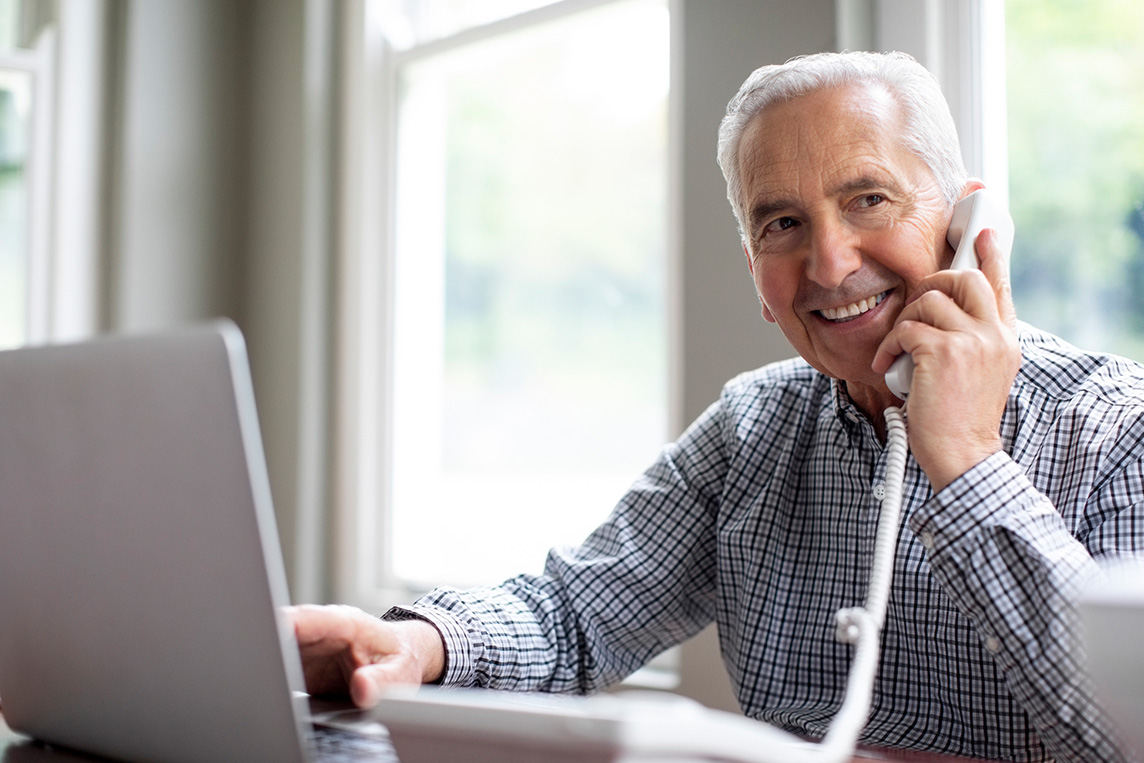 mature man talking on landline phone