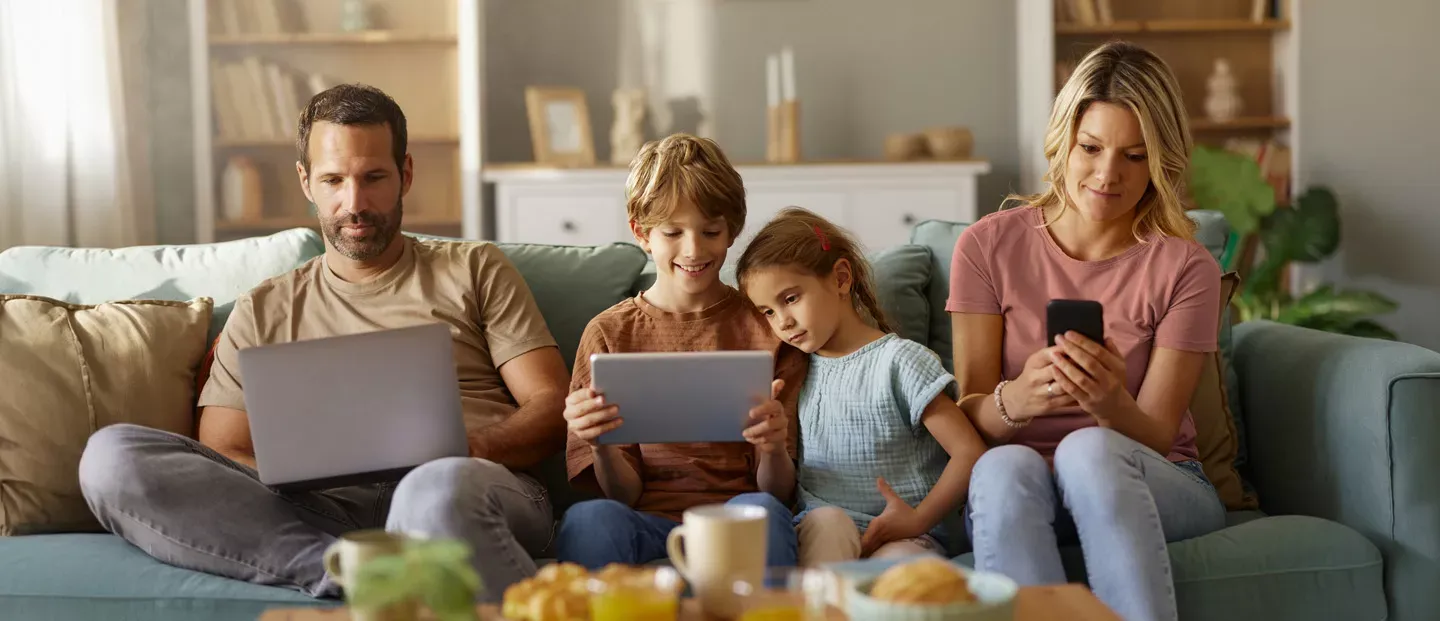 Family using internet together on the sofa.