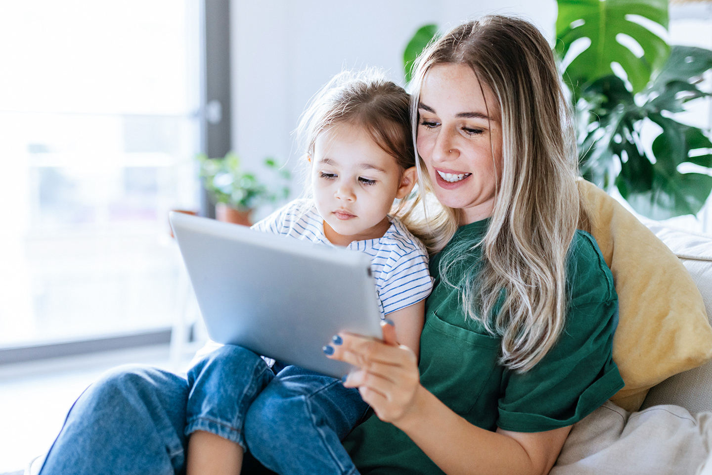 mom and daughter using CenturyLink internet on a tablet in their living room