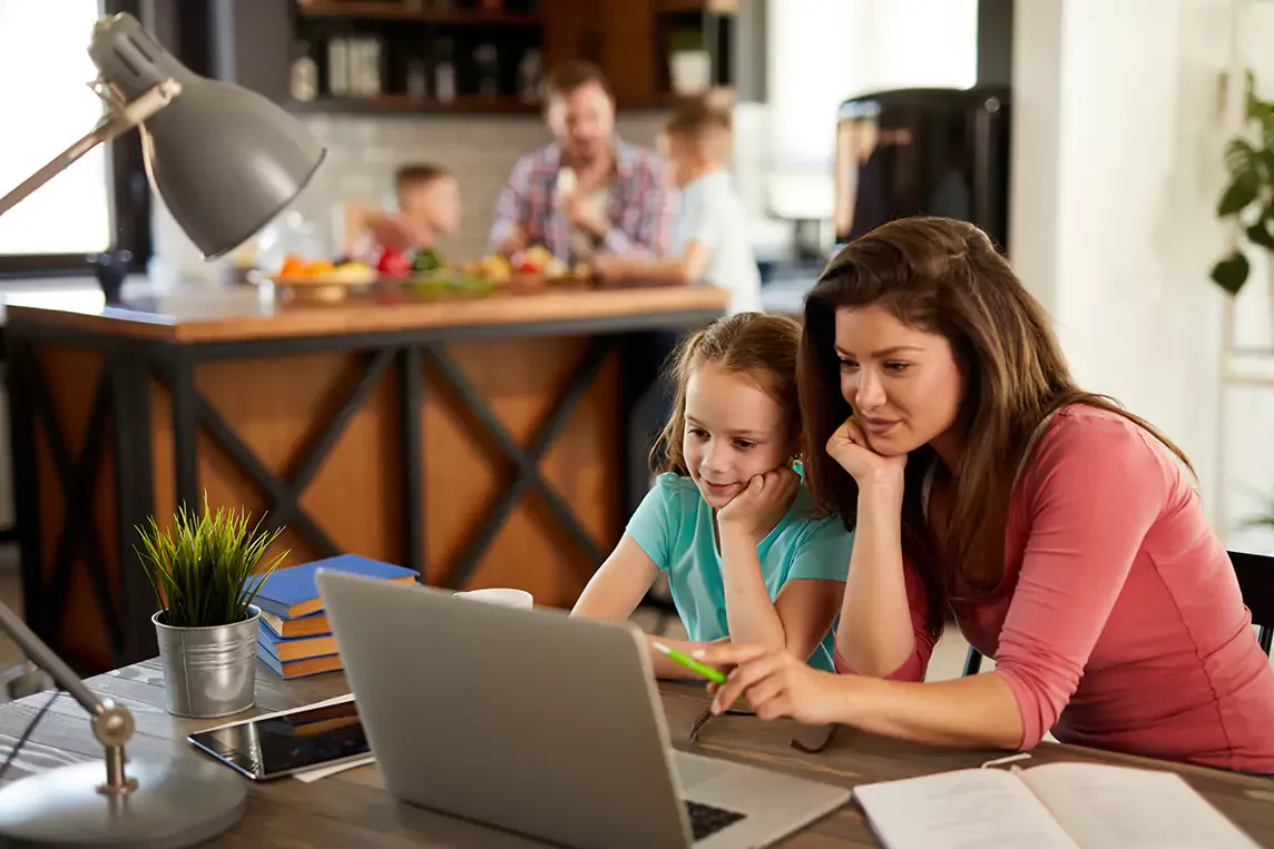 mother and daughter looking at laptop