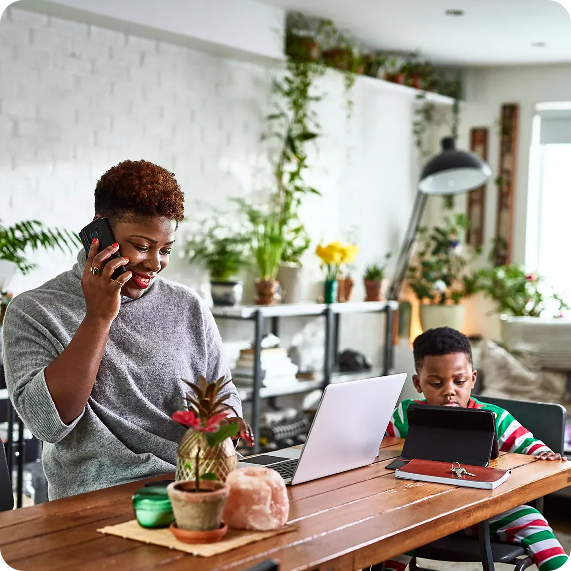 Mother and son with internet devices on kitchen counter