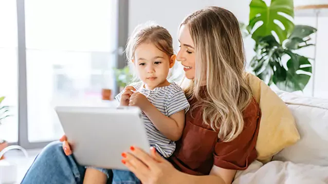 mother and young daughter using tablet