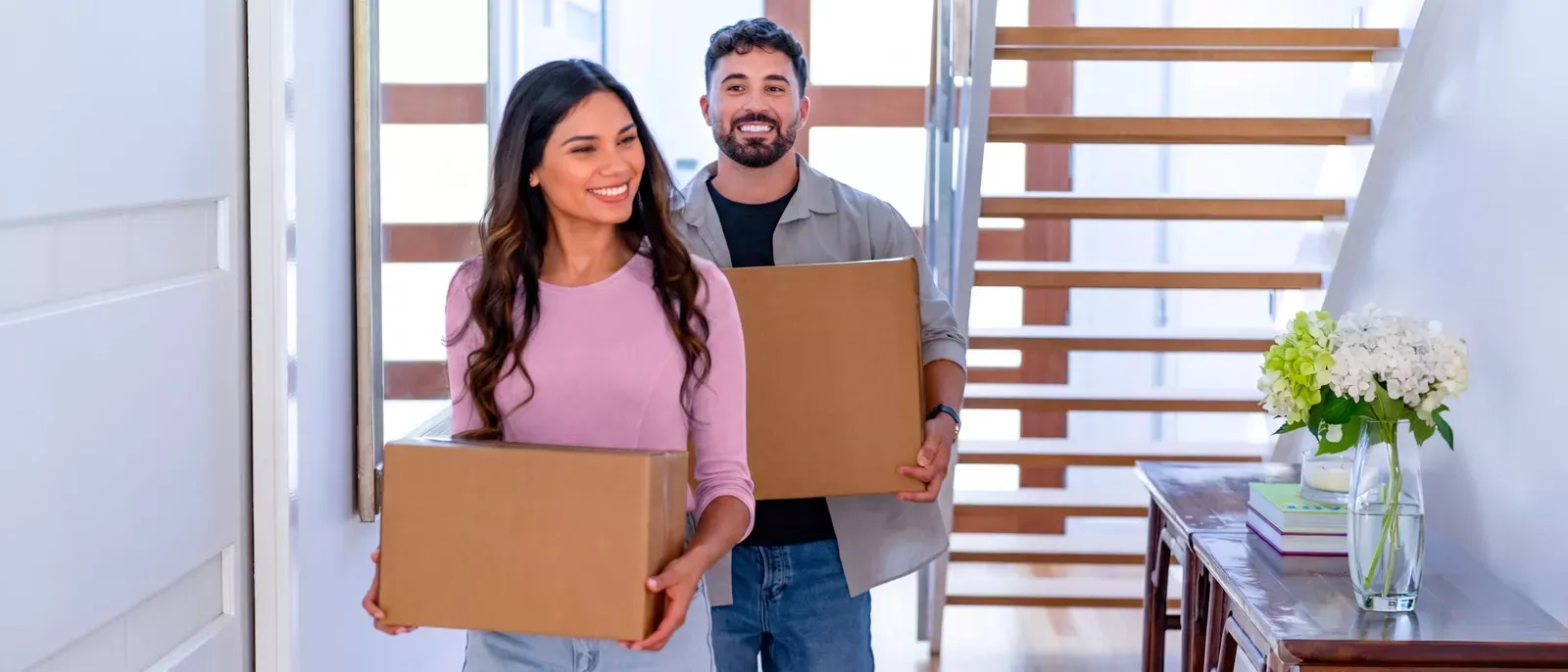 Couple moving in some boxes into their new place.