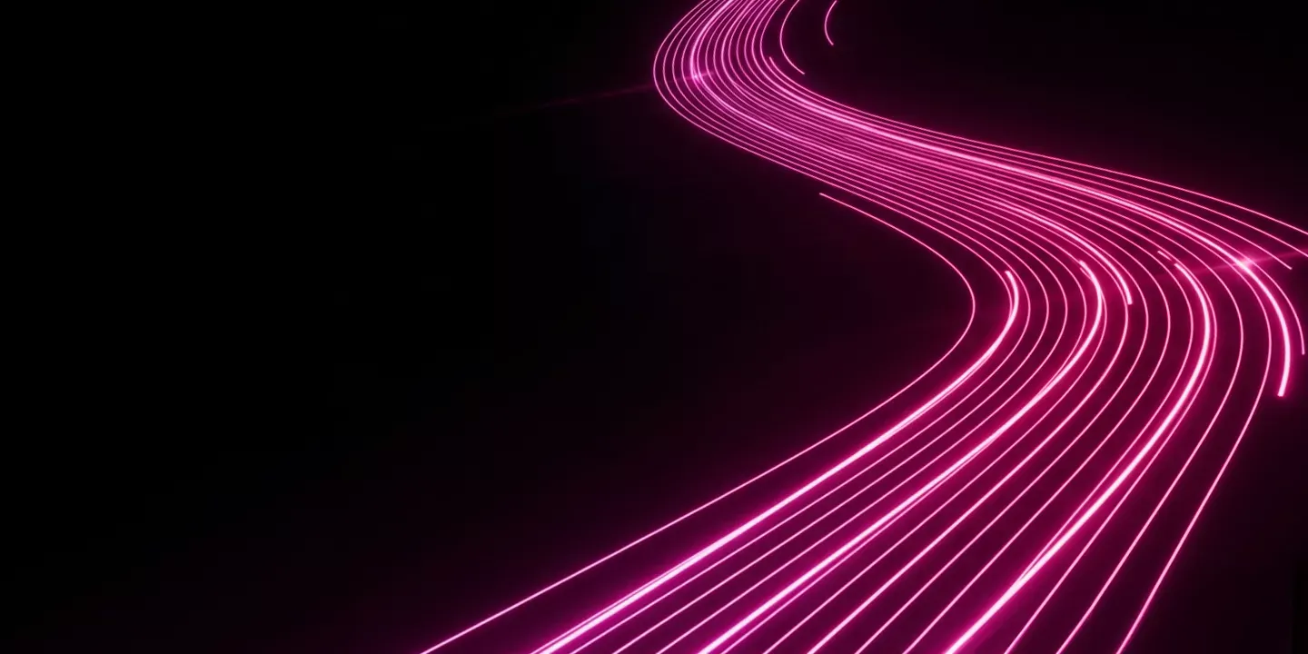 Abstract image showing bright pink light trails curving across a completely black background.