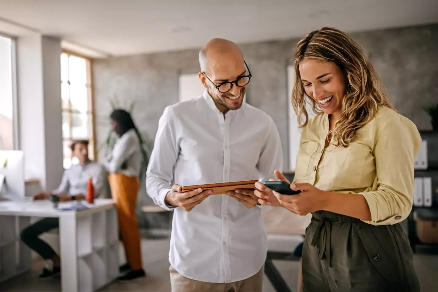 A couple of people using the internet at the office.