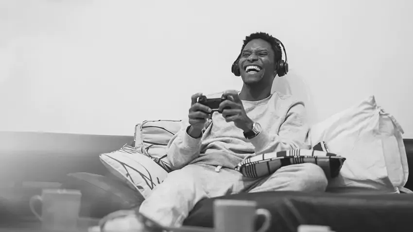 man playing video games on couch