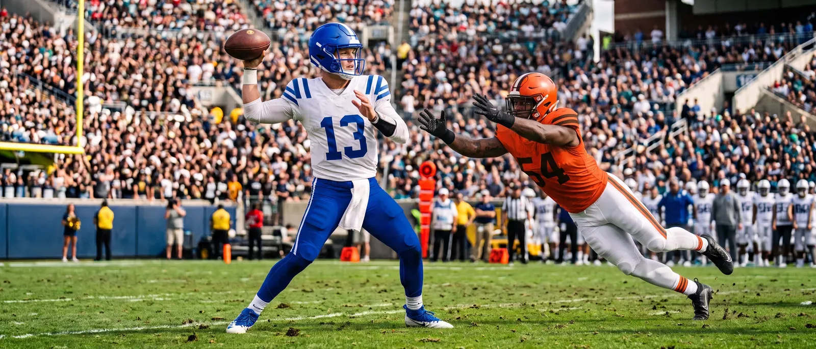 A football quarterback wearing a blue and white uniform number 13 winds up to throw a pass as a defender in orange lunges toward him.