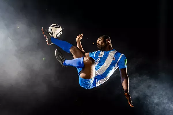 Professional MLS player kicks ball in the air