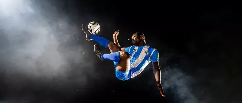 Professional MLS player kicks ball in the air