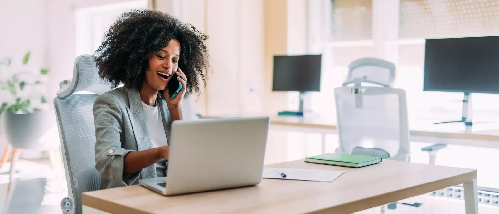 Business owner using laptop and chatting on the phone.