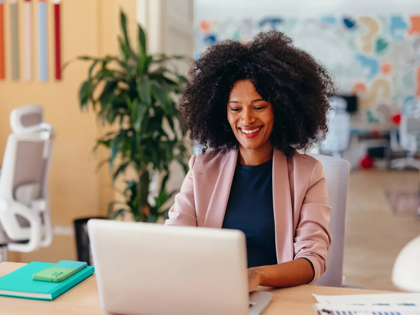 Smiling small business woman working on her laptop in her office.