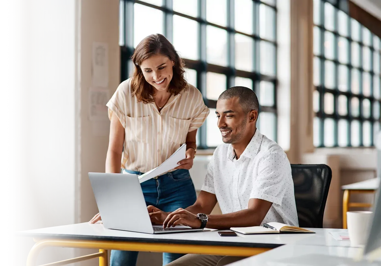 Two people collaborating on a project in their small office.