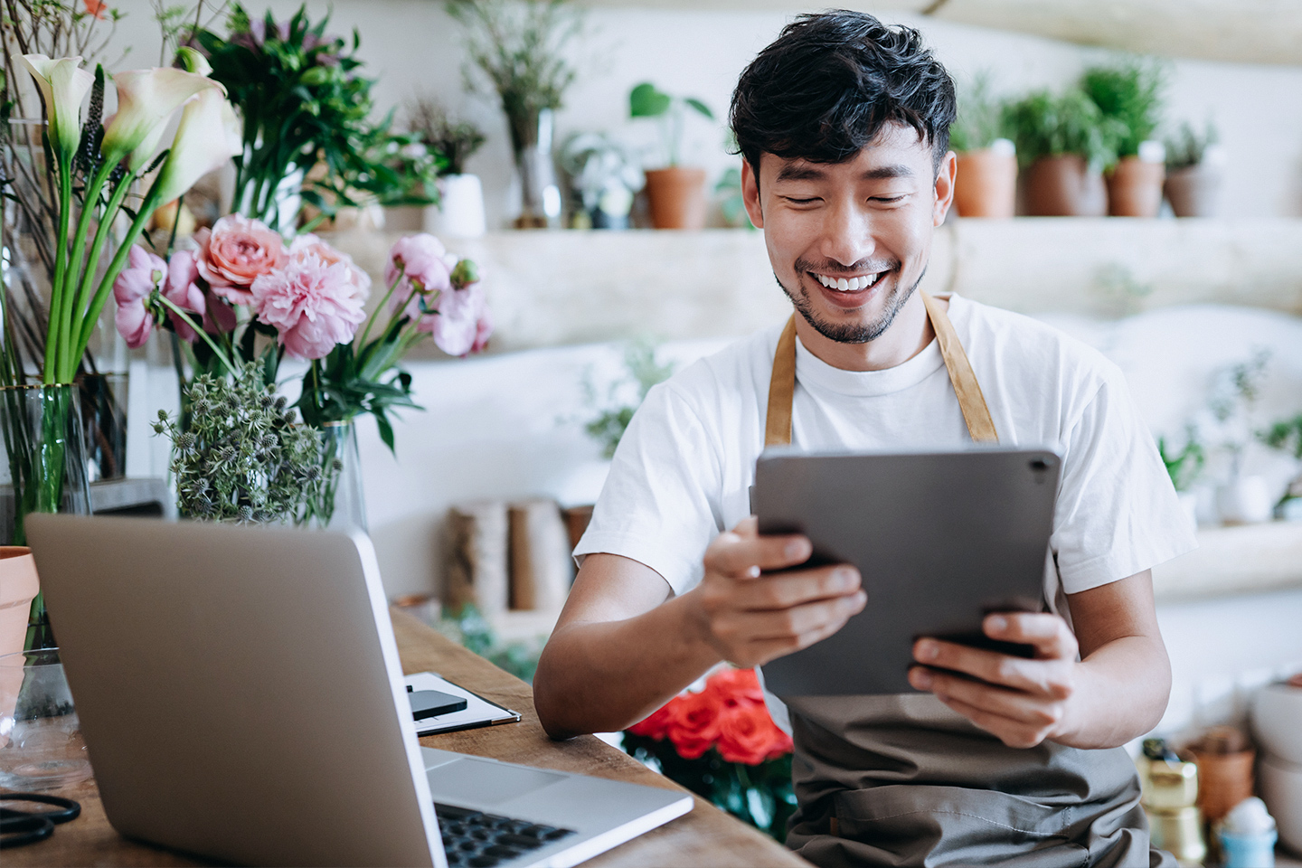 owner of small business flower shop, using tablet while working