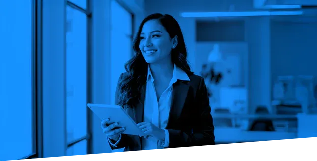 Smiling business woman dressed in a professional button down shirt and jacket holding a tablet.