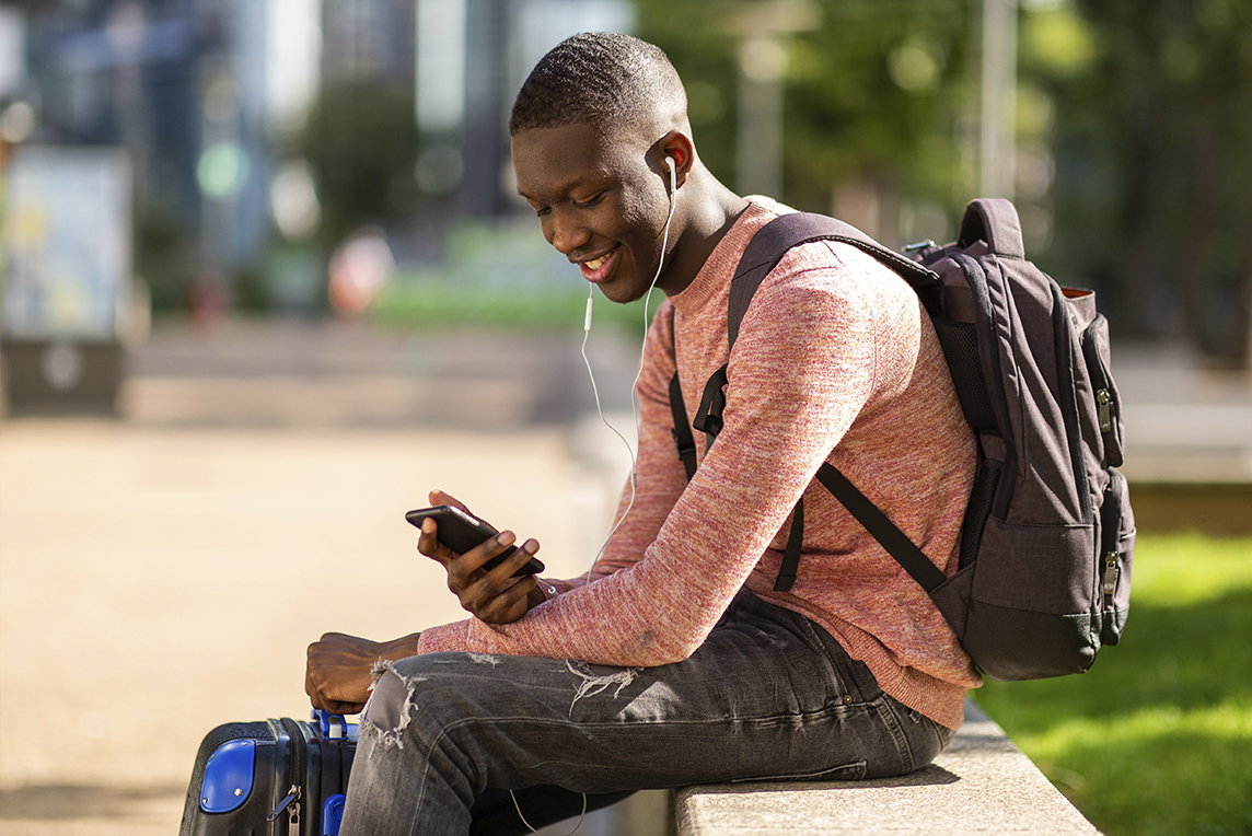 Man watching on phone outside a park