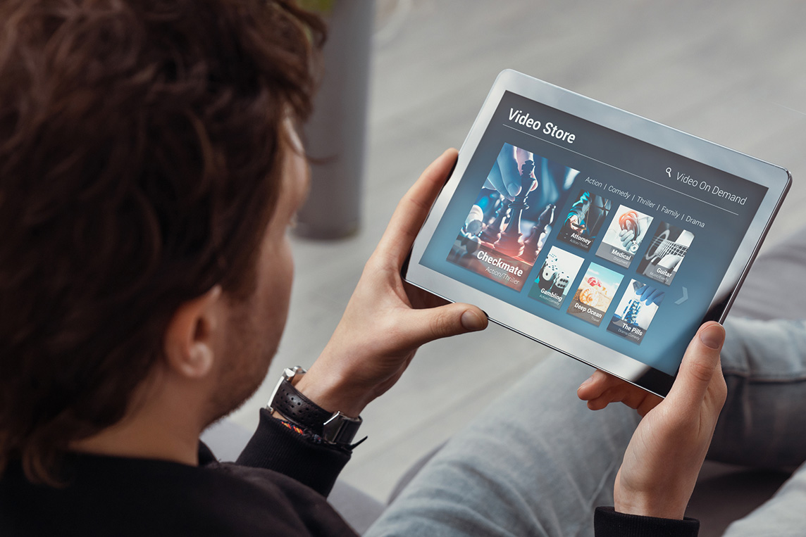 man streaming movie on tablet