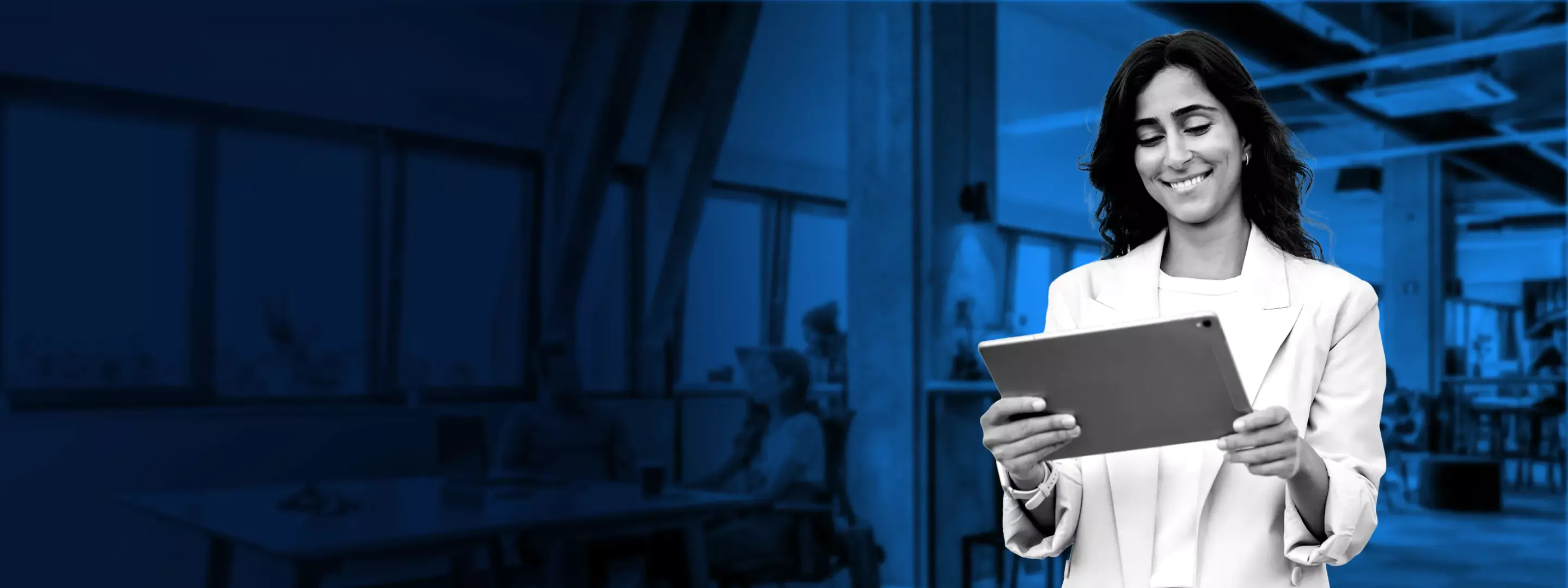 Smiling business woman with a tablet, in an office overlayed with a blue color.