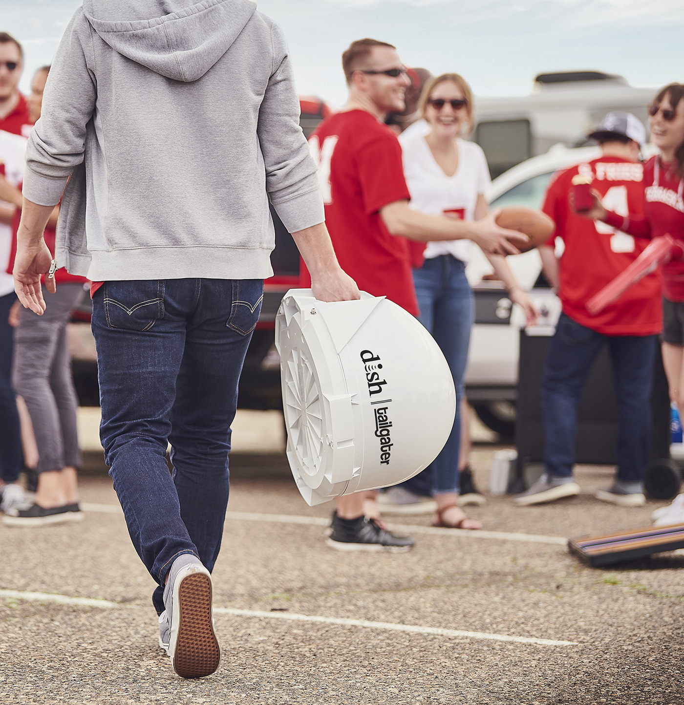 man carrying the DISH tailgater to tailgate party