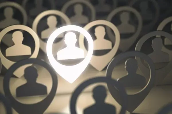 A digital illustration showing a crowd of identical, silhouetted human figures inside map pin icons, with one pin in the foreground glowing brightly, suggesting a highlighted person or a singled-out individual.