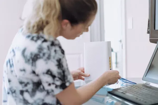 A woman checking her routers connection.