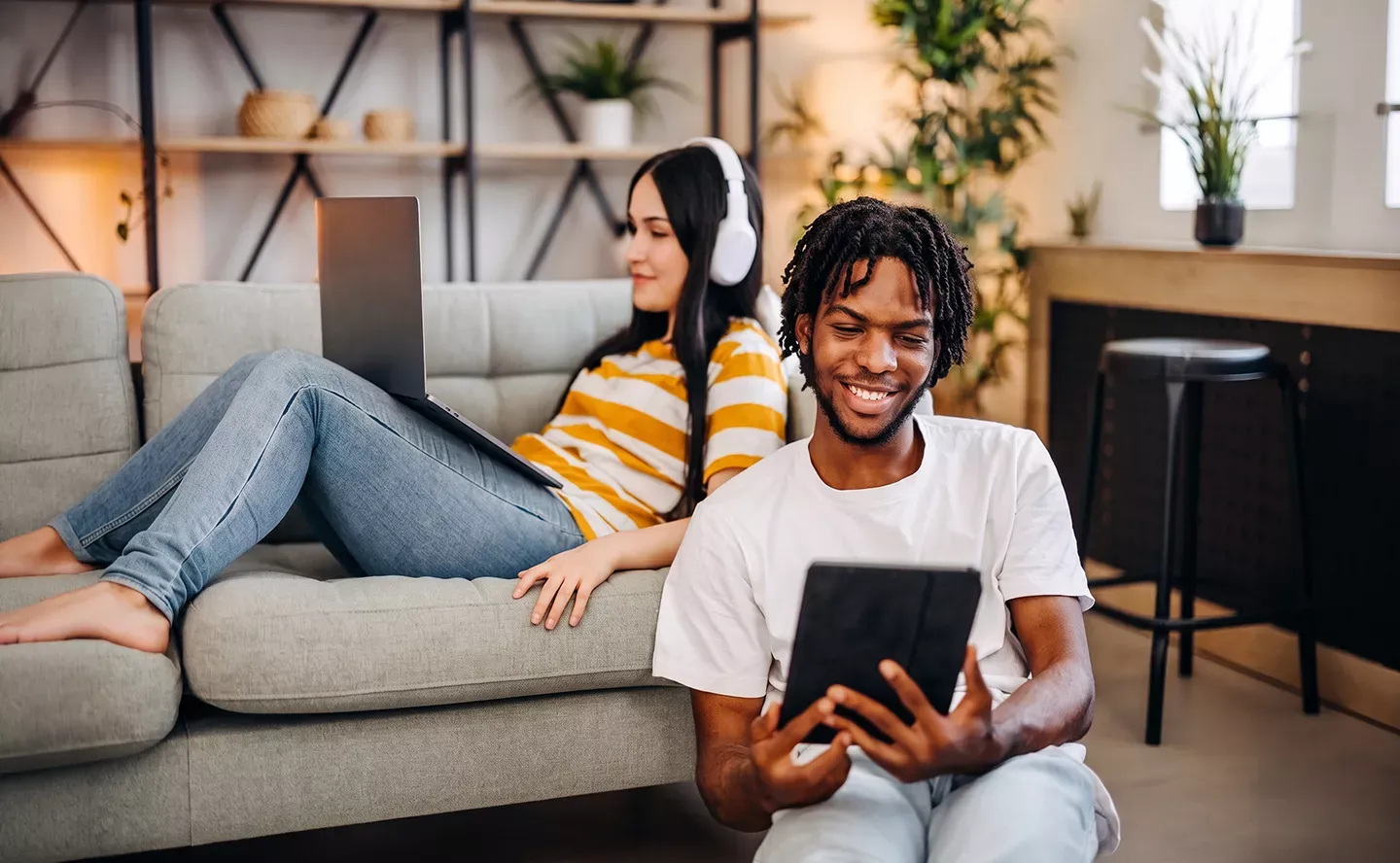 Two friends use multiple internet devices with fast internet at home