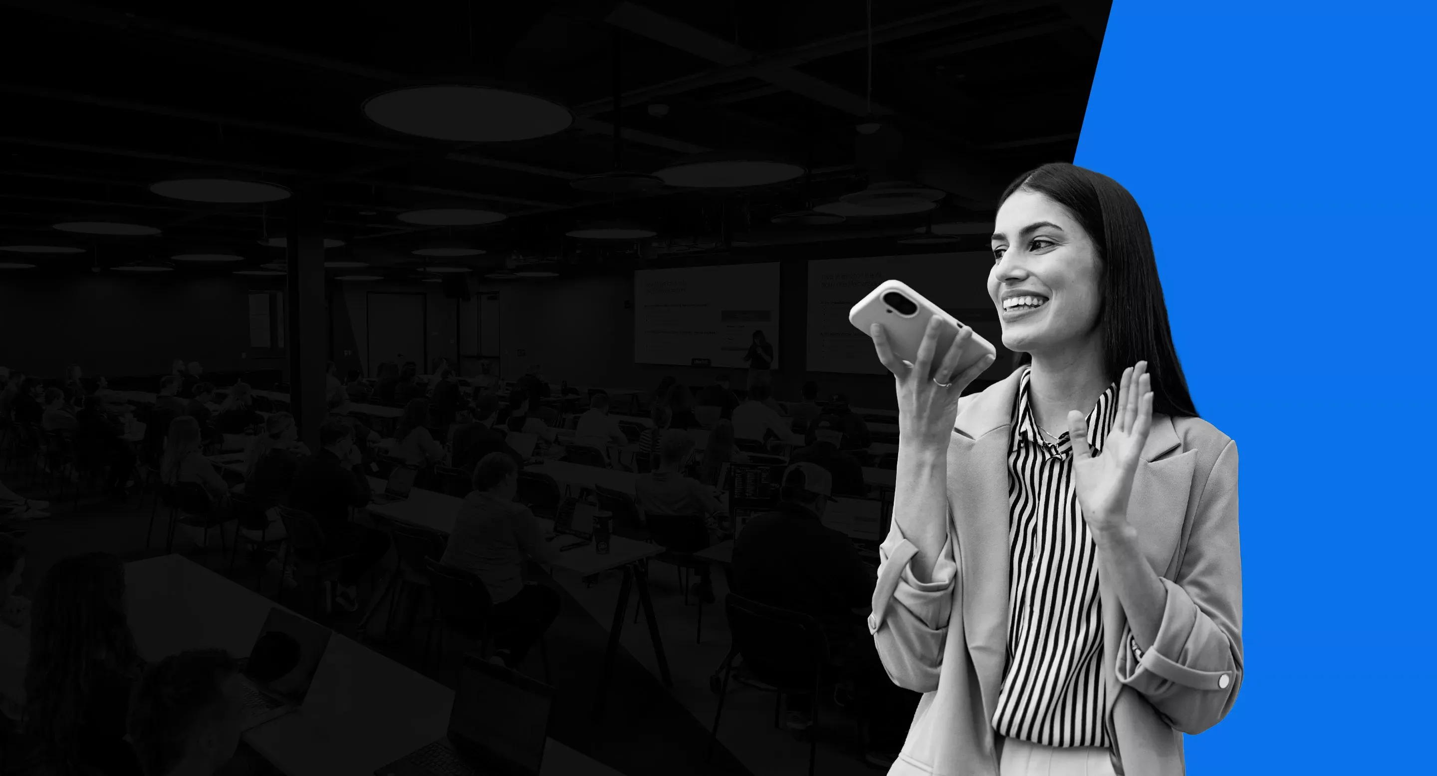 woman participating in business call on a cell phone in front of a room of people