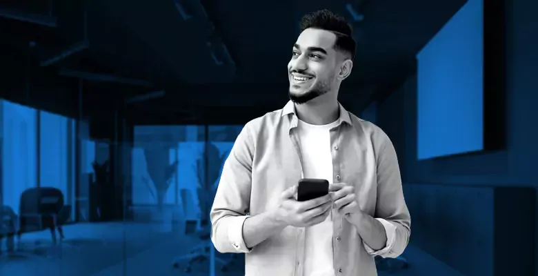 man in an office on a smartphone
