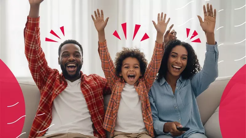 A happy family of three cheering with their arms raised while sitting on a couch, featuring red graphic accents and a light background.