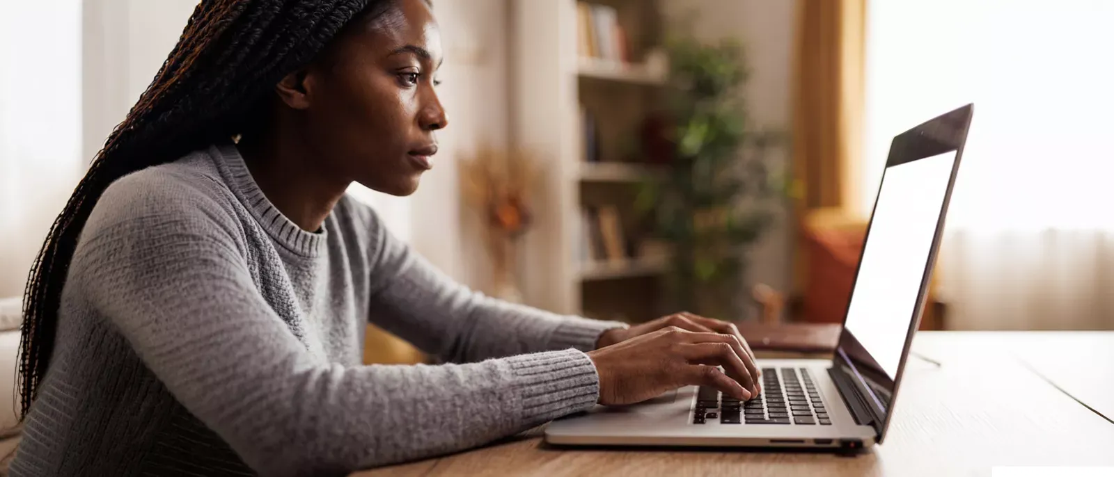 Woman using a laptop and contemplating her internet speed.