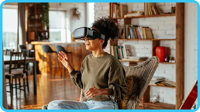 A woman smiles while gesturing with her hand during a VR headset session.