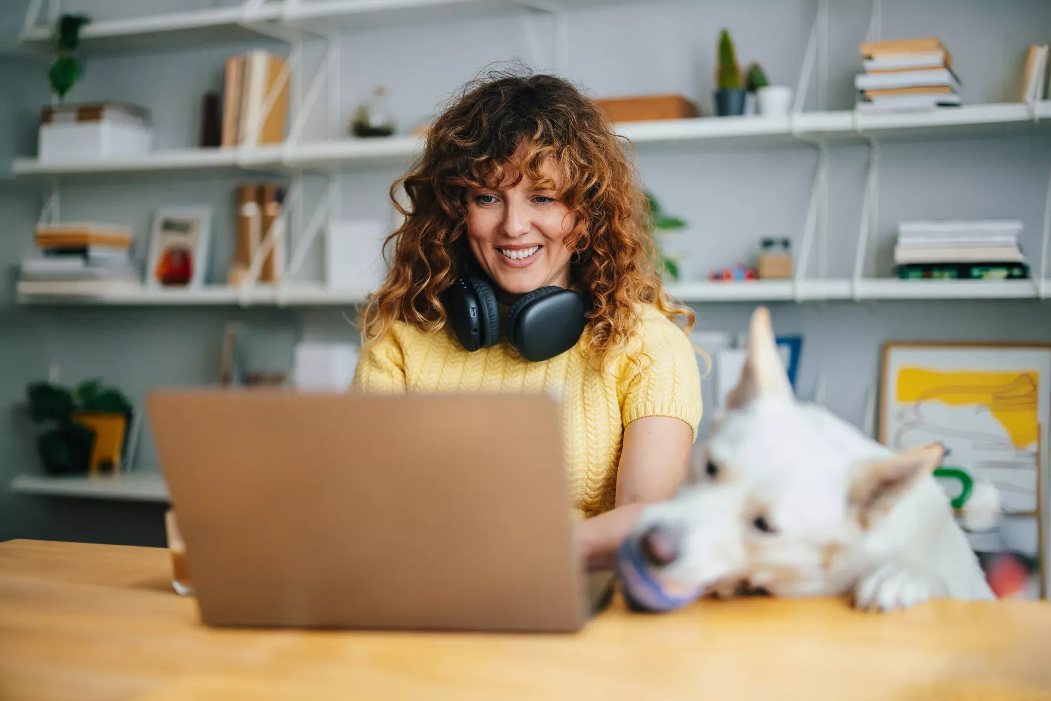 Woman with dog uses laptop at home