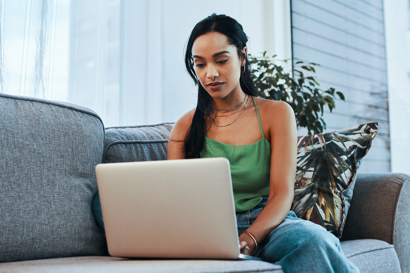 Woman sitting on sofa with laptop
