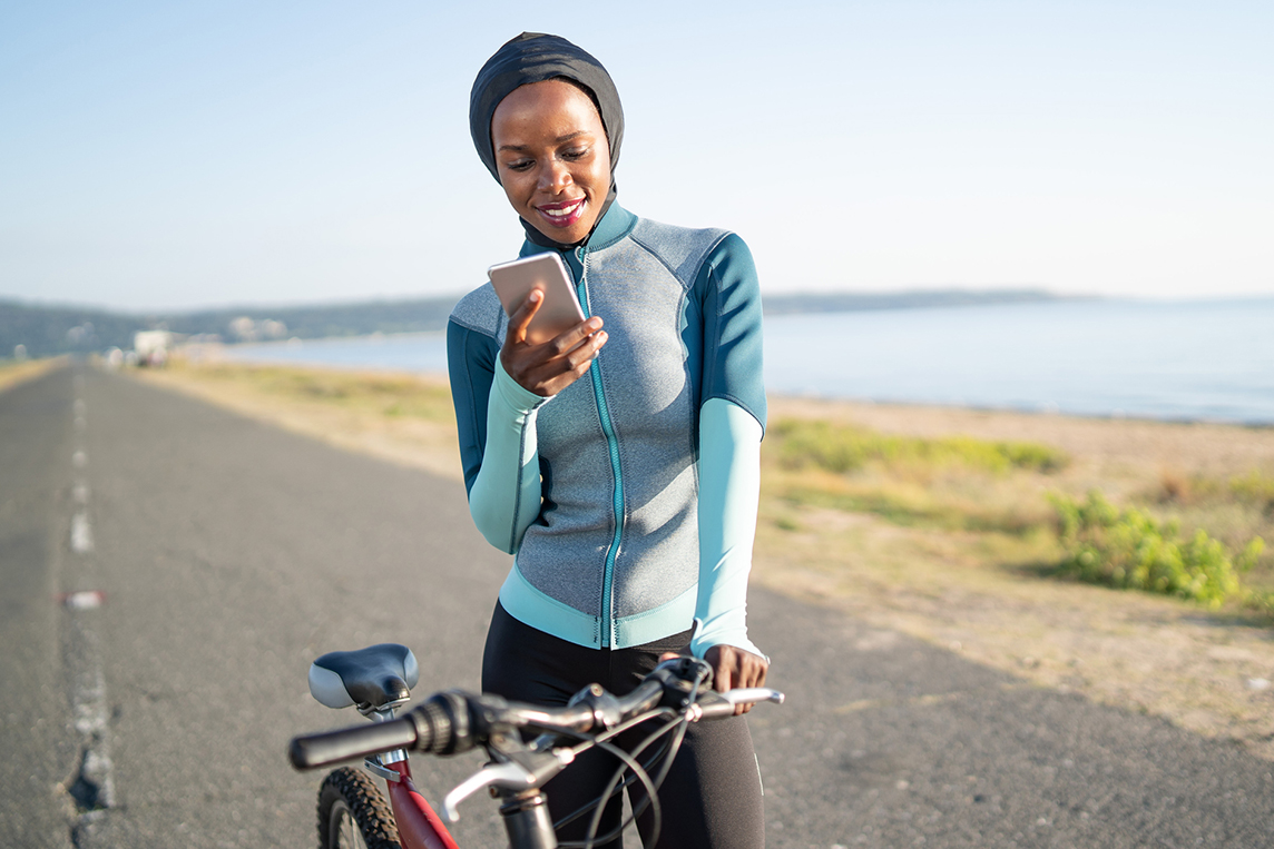 Woman using cell phone on bike ride