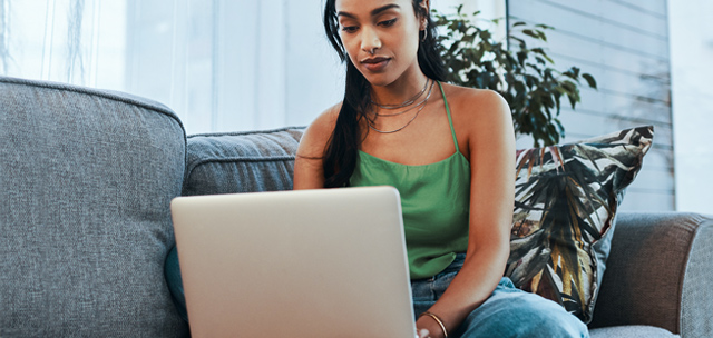 Woman sitting on sofa with laptop