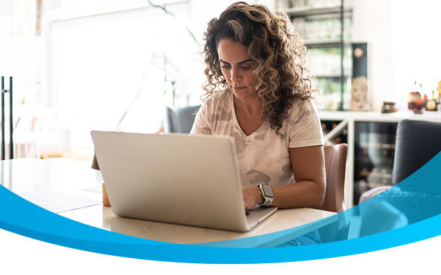 Woman working on laptop in kitchen