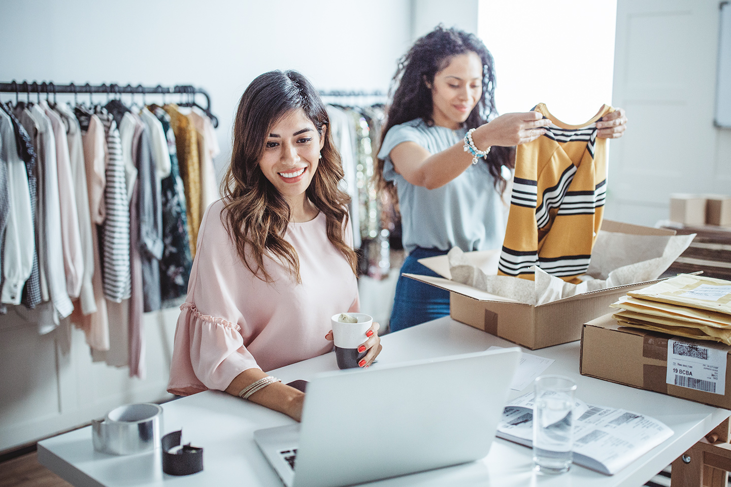 Women working at their store, accepting new orders online and packing merchandise for customer