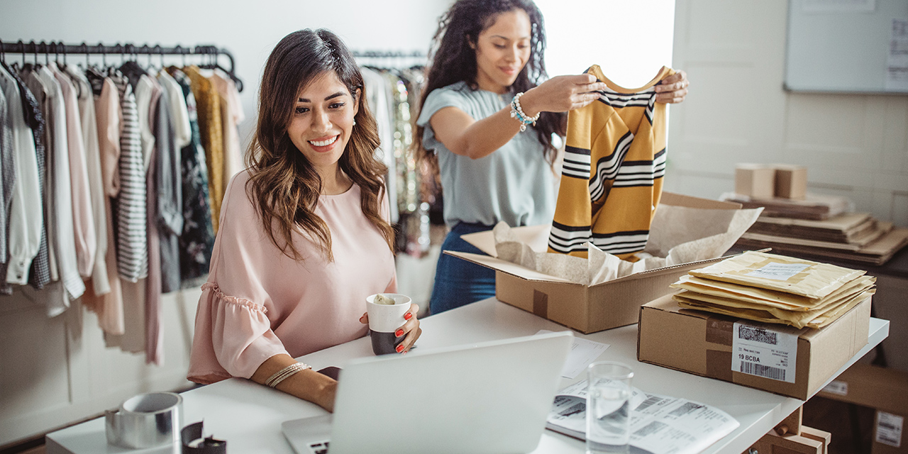Women working at their store, accepting new orders online and packing merchandise for customer