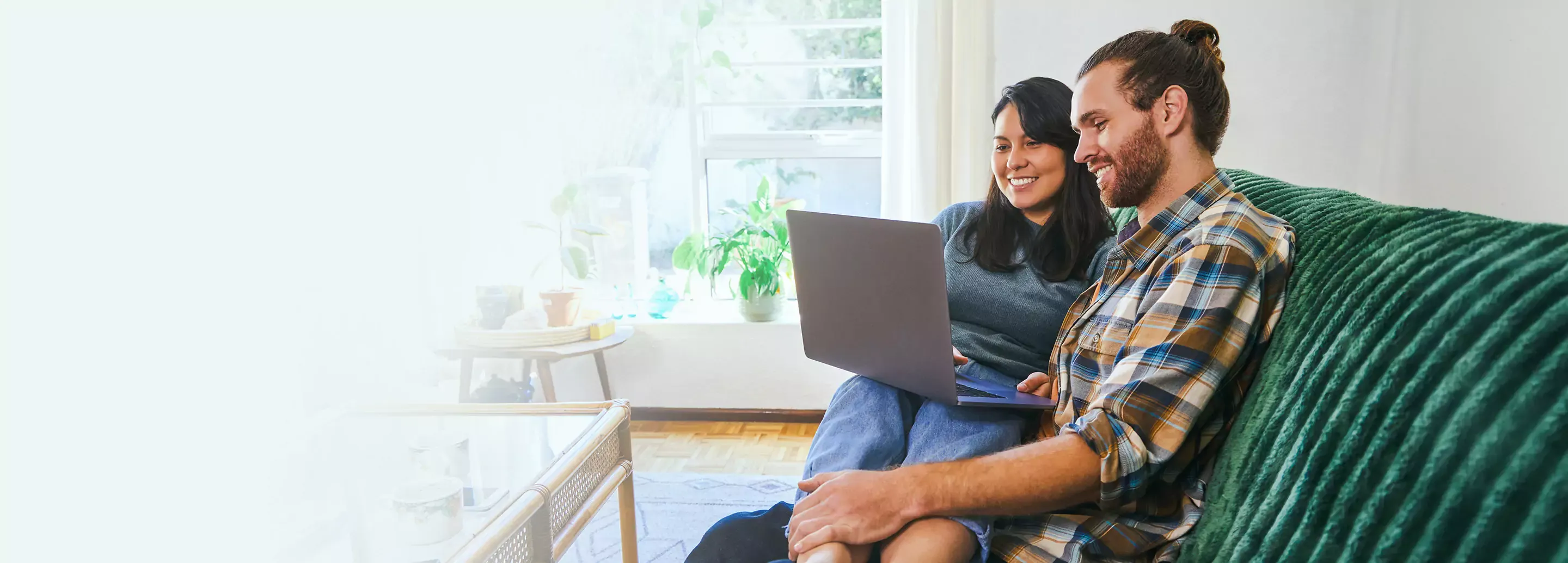 young couple relaxing together while using their laptop