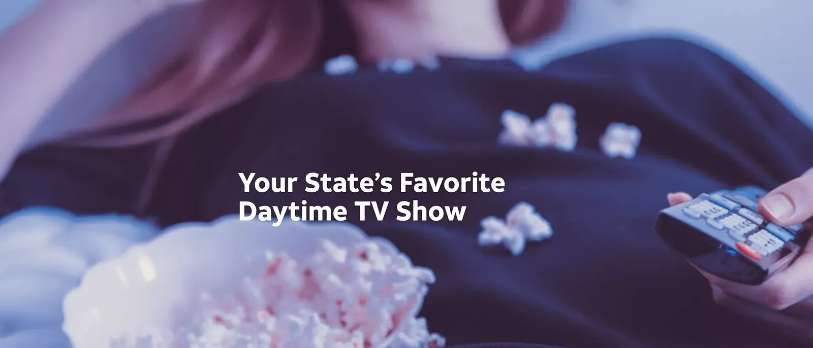Woman eats popcorn while watching TV