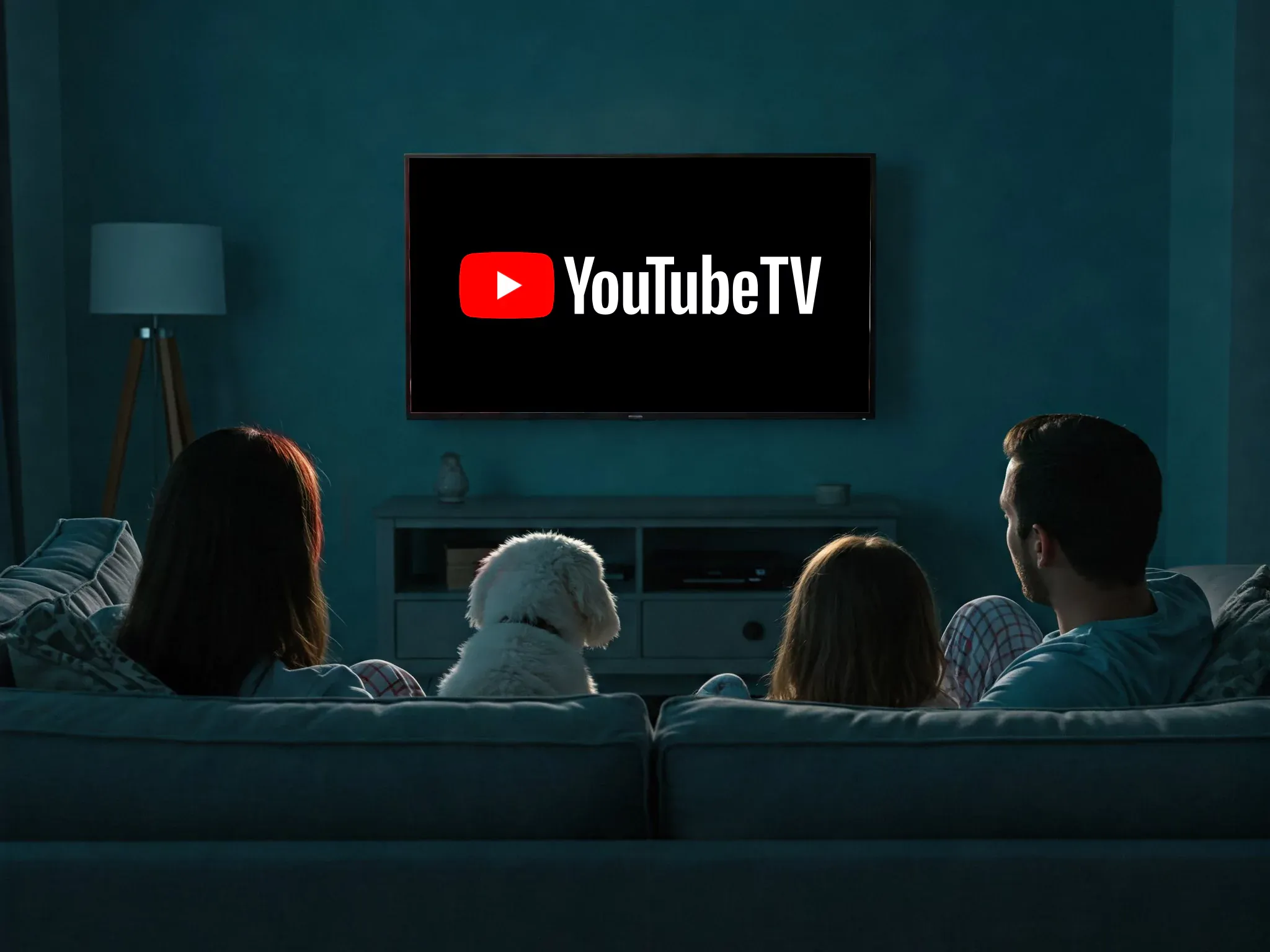 A view from behind of a familiy and their dog watching youtube tv.